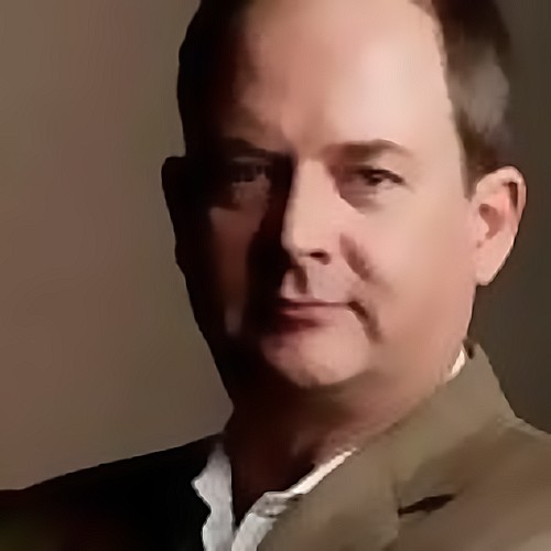 a headshot of a man in a suit