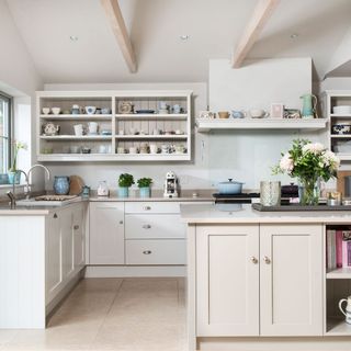 white open plan kitchen with island and white doorlesss display shelves