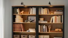 IKEA Billy bookcase lighting over the top, with shelves styled with books and decor 