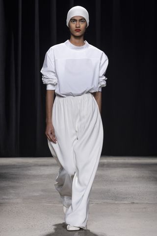 All white Fforme runway look from the FW24 show that includes a swim cap like hat, a white sweatshirt, and relaxed white pants