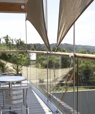Small shade sails attached vertically to a balcony railing