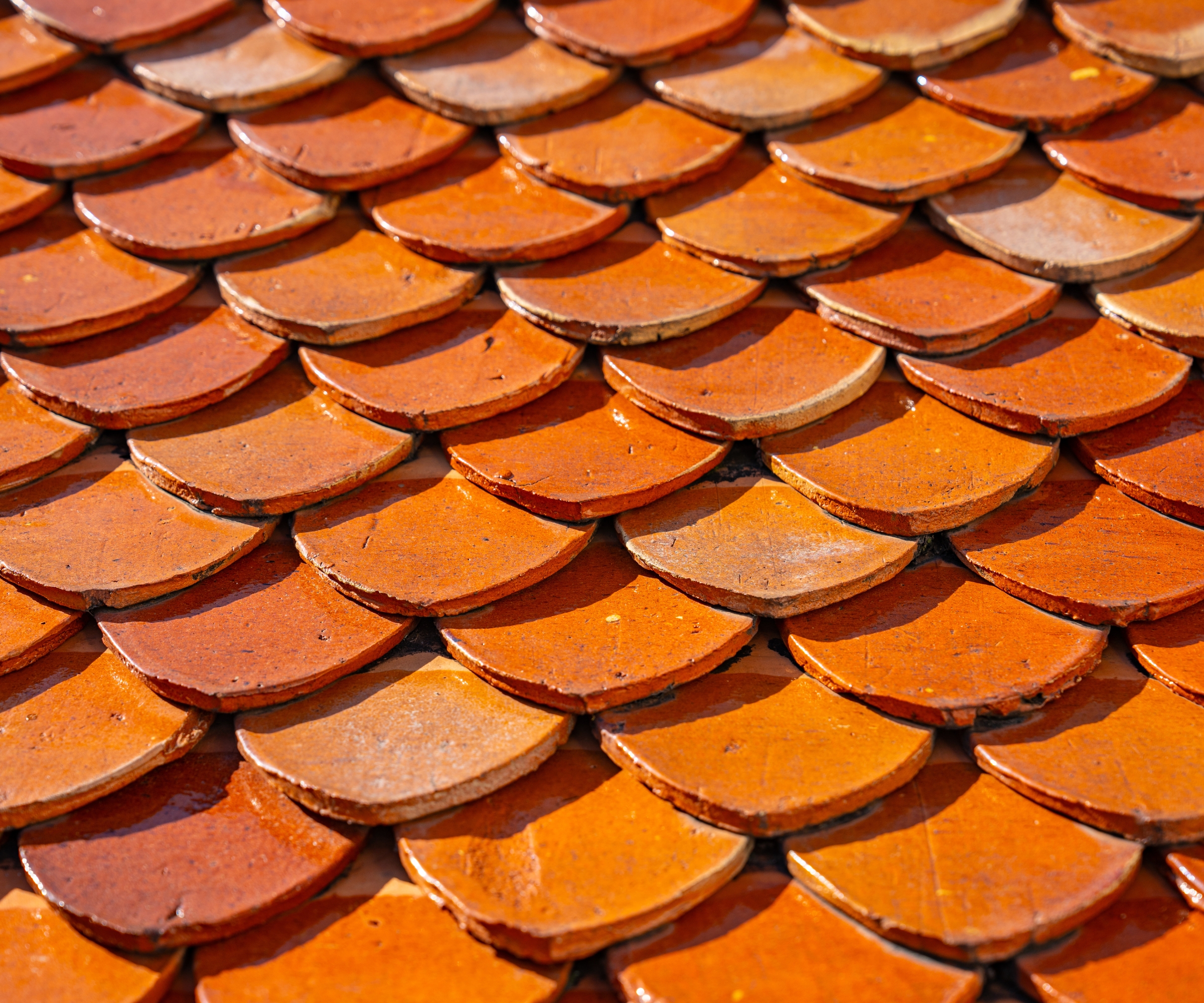 Red clay roof tiles, close up, in the sunshine.
