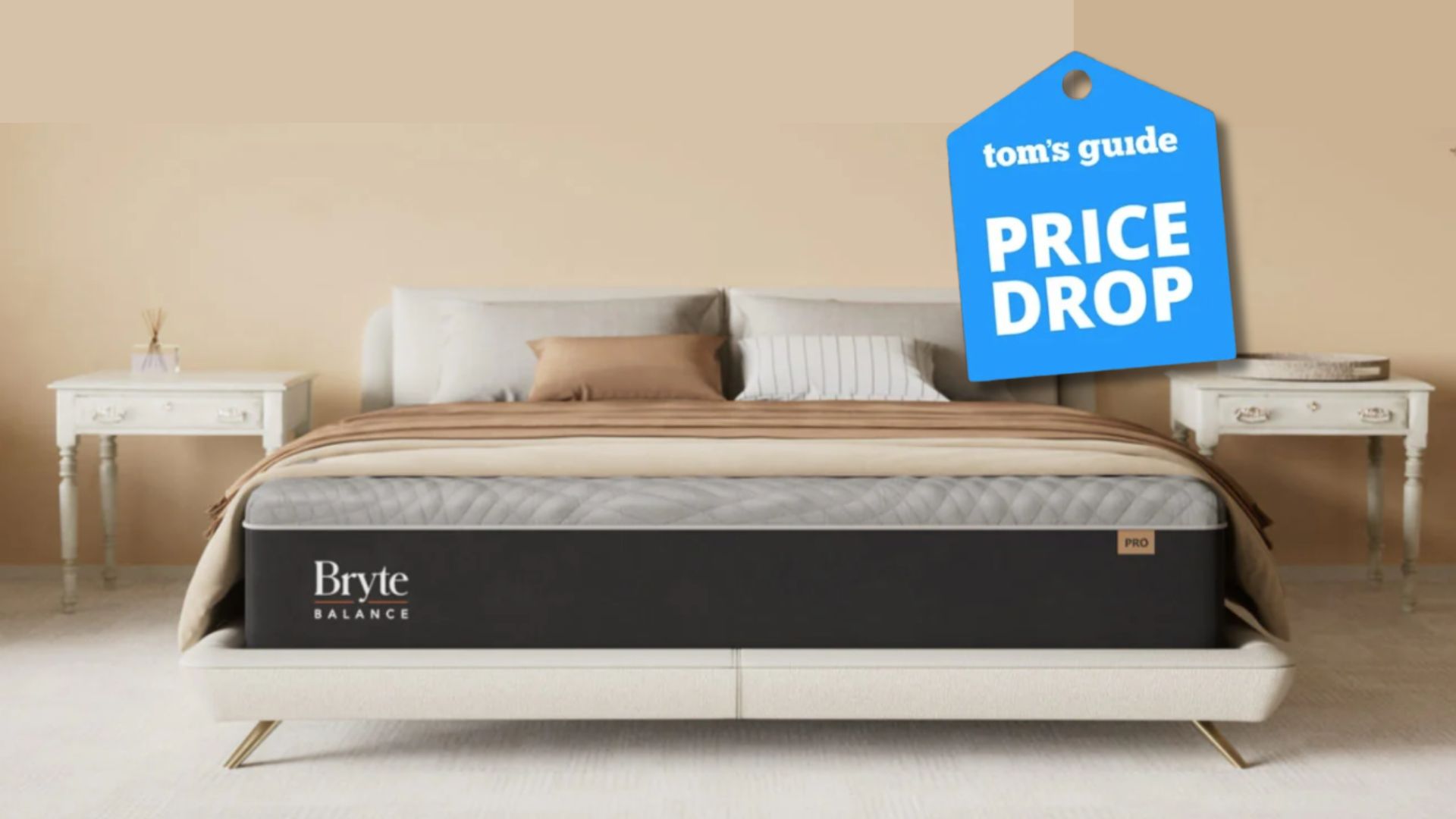 Grey and black Bryte Balance smart bed in bedroom with beige wall, two white bedside tables and beige and white pillows