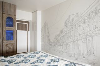 A small bedroom with an entire wall with a painted mural