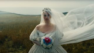 Shot from the new Wuthering Heights trailer of a veiled wedding dress clad Margot Robbie holding a bouquet of jewel tone flowers