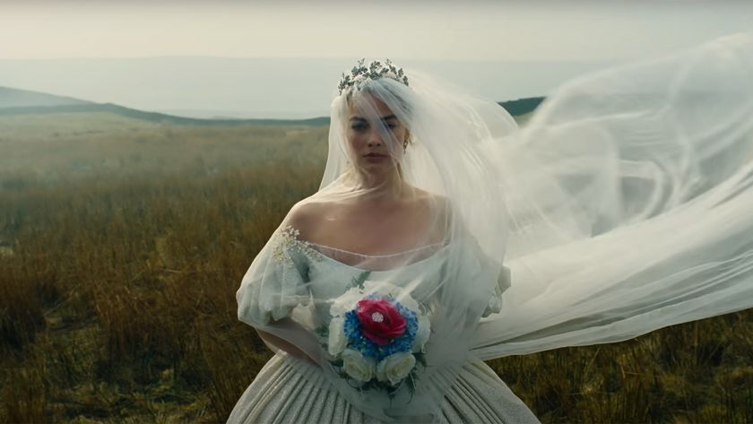 Shot from the new Wuthering Heights trailer of a veiled wedding dress clad Margot Robbie holding a bouquet of jewel tone flowers