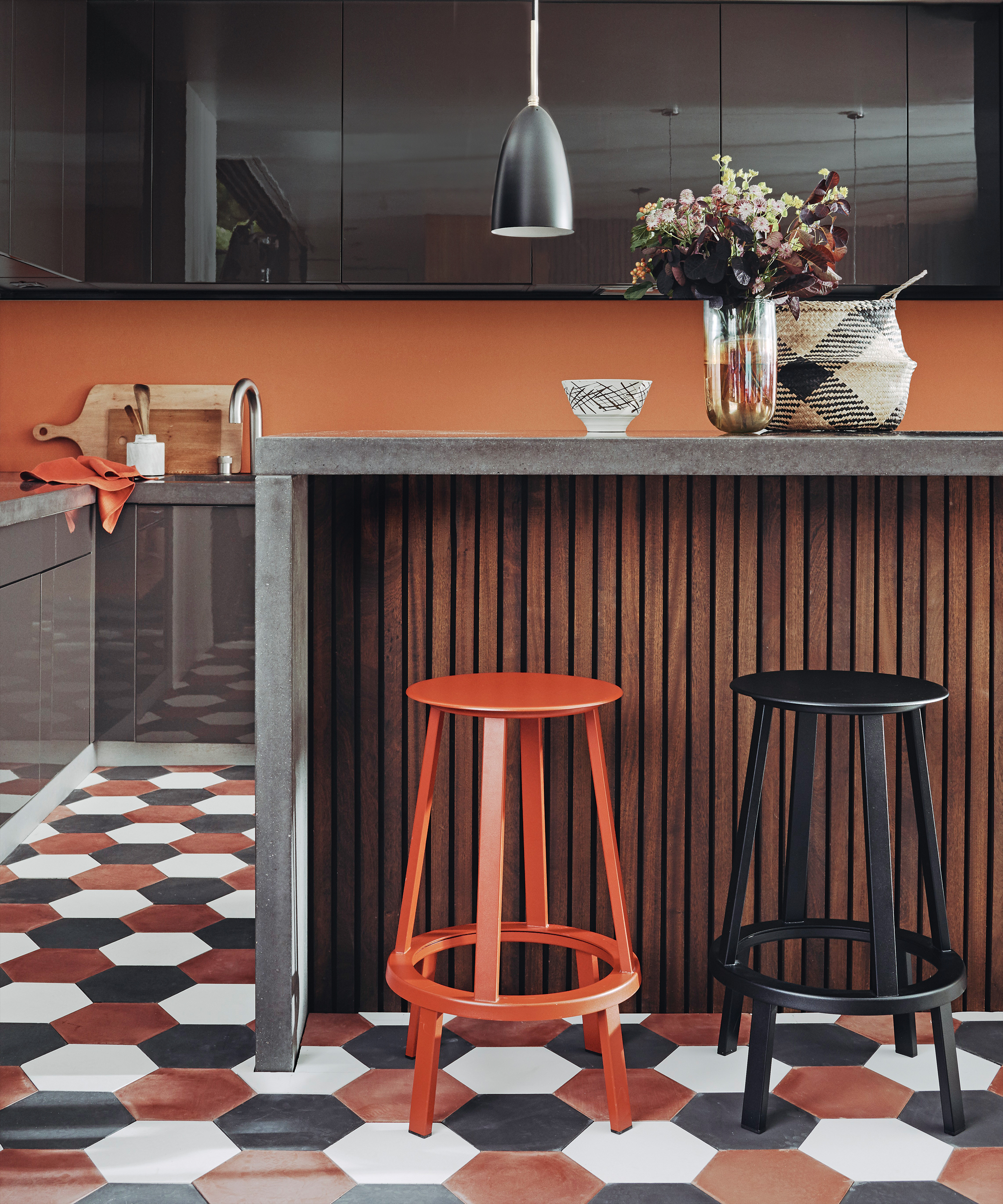 A kitchen with hexagonal kitchen floor tile ideas in white, burnt orange and black.