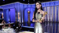 Demi Moore holding her Golden Globe award