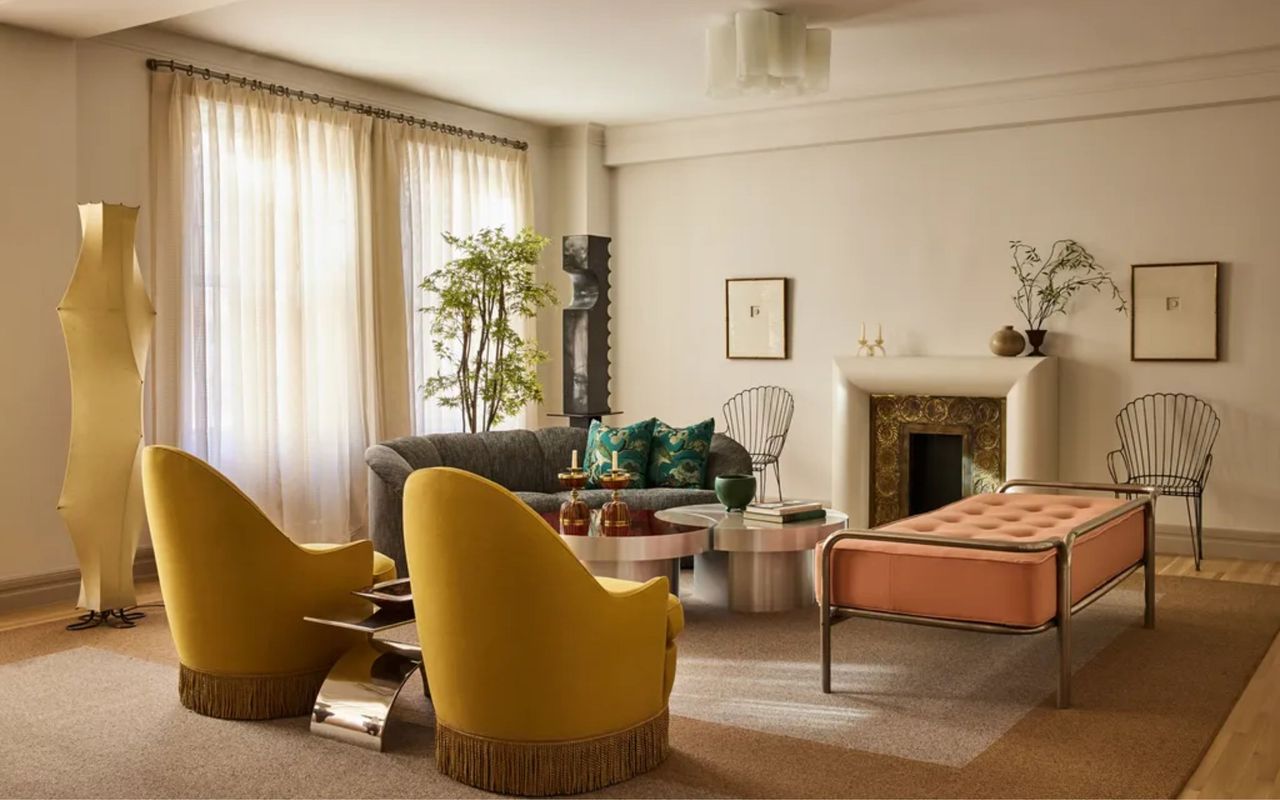 Living room with cream walls, yellow chairs, and sheer curtains