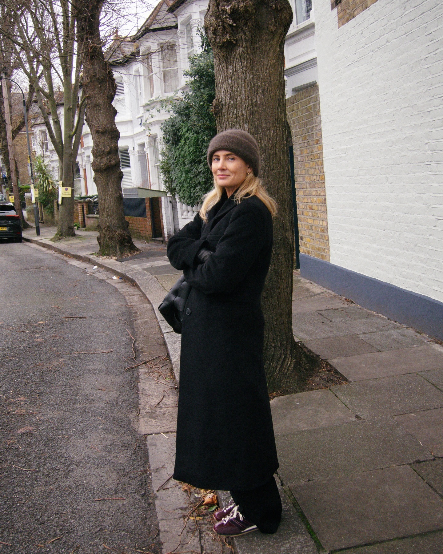 Lucy in a black wool coat and brown beanie hat