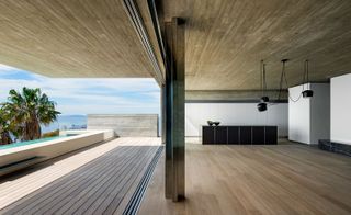 Outdoor decking is sheltered by the cantilever of the master bedroom above