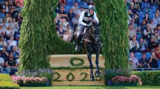J&eacute;r&ocirc;me Robin&eacute; and Black Ice jump a cross-country fence at Aachen 2025.