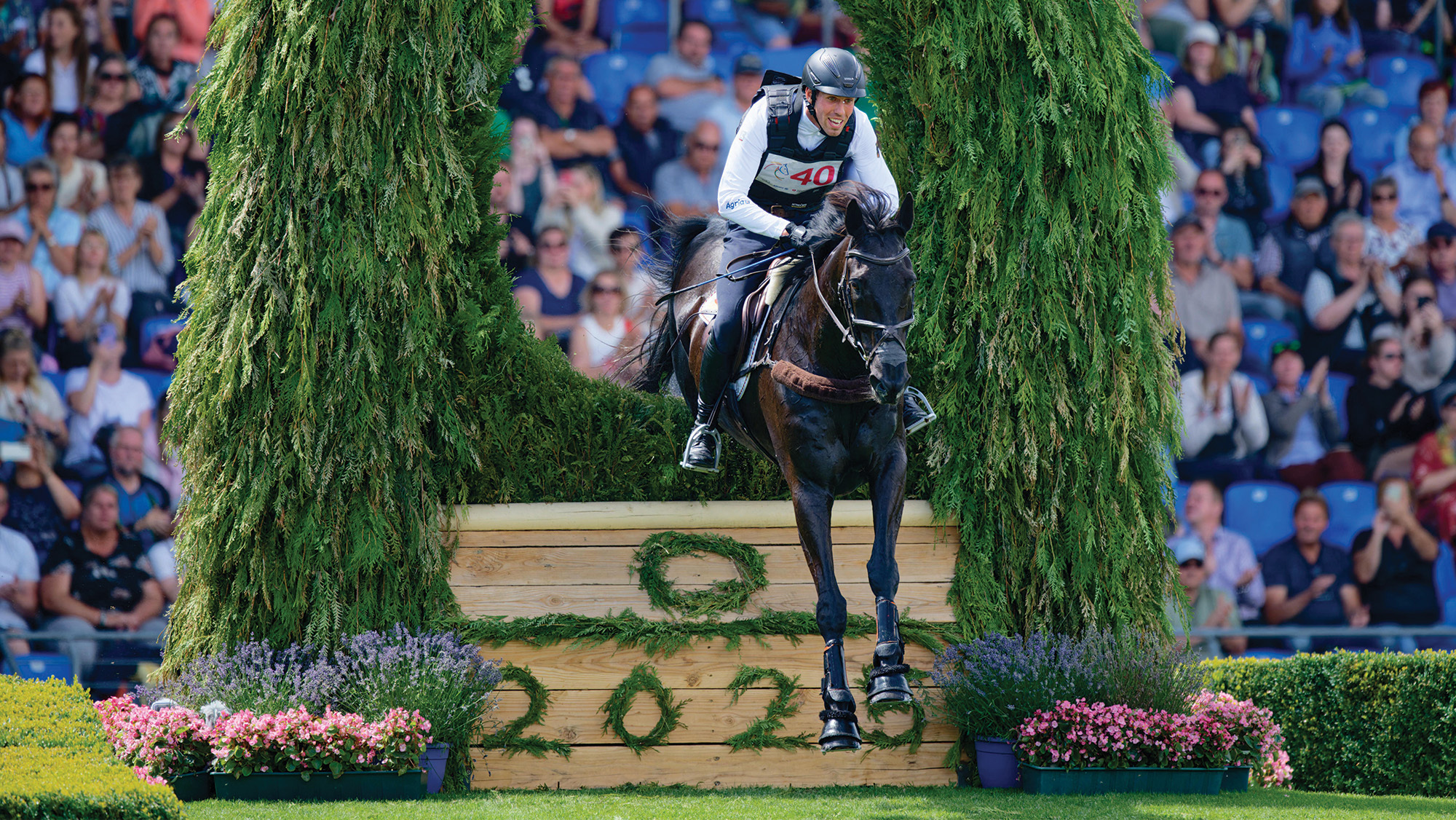 J&eacute;r&ocirc;me Robin&eacute; and Black Ice jump a cross-country fence at Aachen 2025.