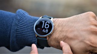En OnePlus Watch i Cobalt Limited Edition runt en mans handled utomhus.