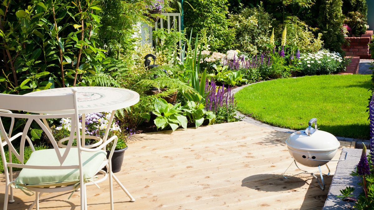 small wooden deck in garden with circular lawn