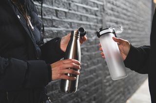 Two people holding water bottles