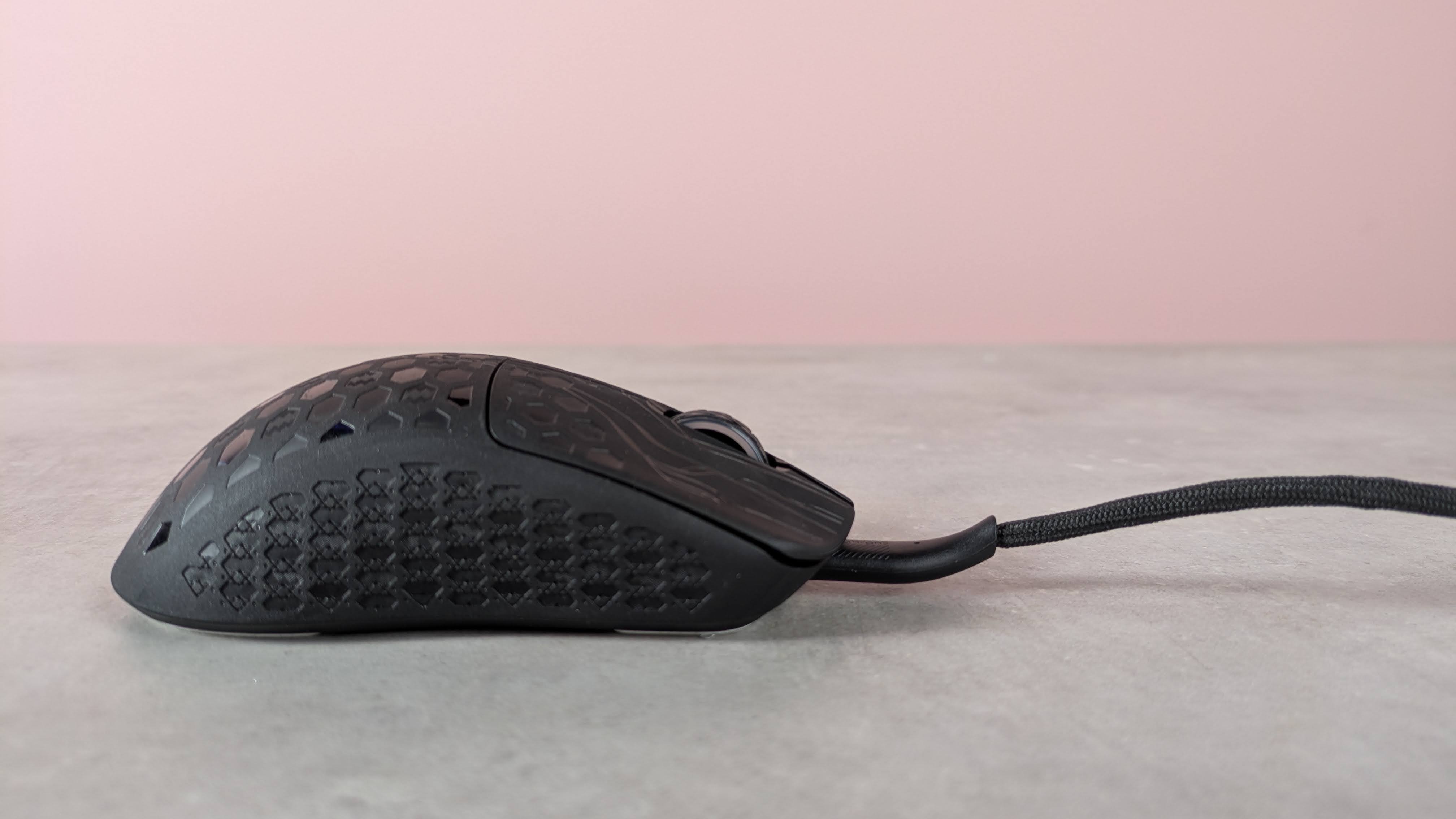 Side view of Keychron G5 with cable attached, on a desk with pink wall in background