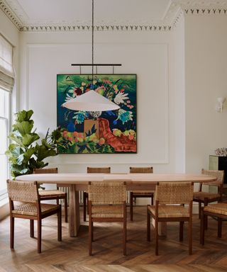 A light-filled dining room with high ceilings, crown molding, and a large wooden table