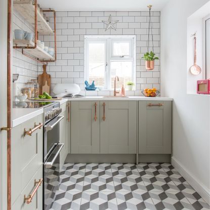 A sage green and white kitchen with a geometric statement flooring design