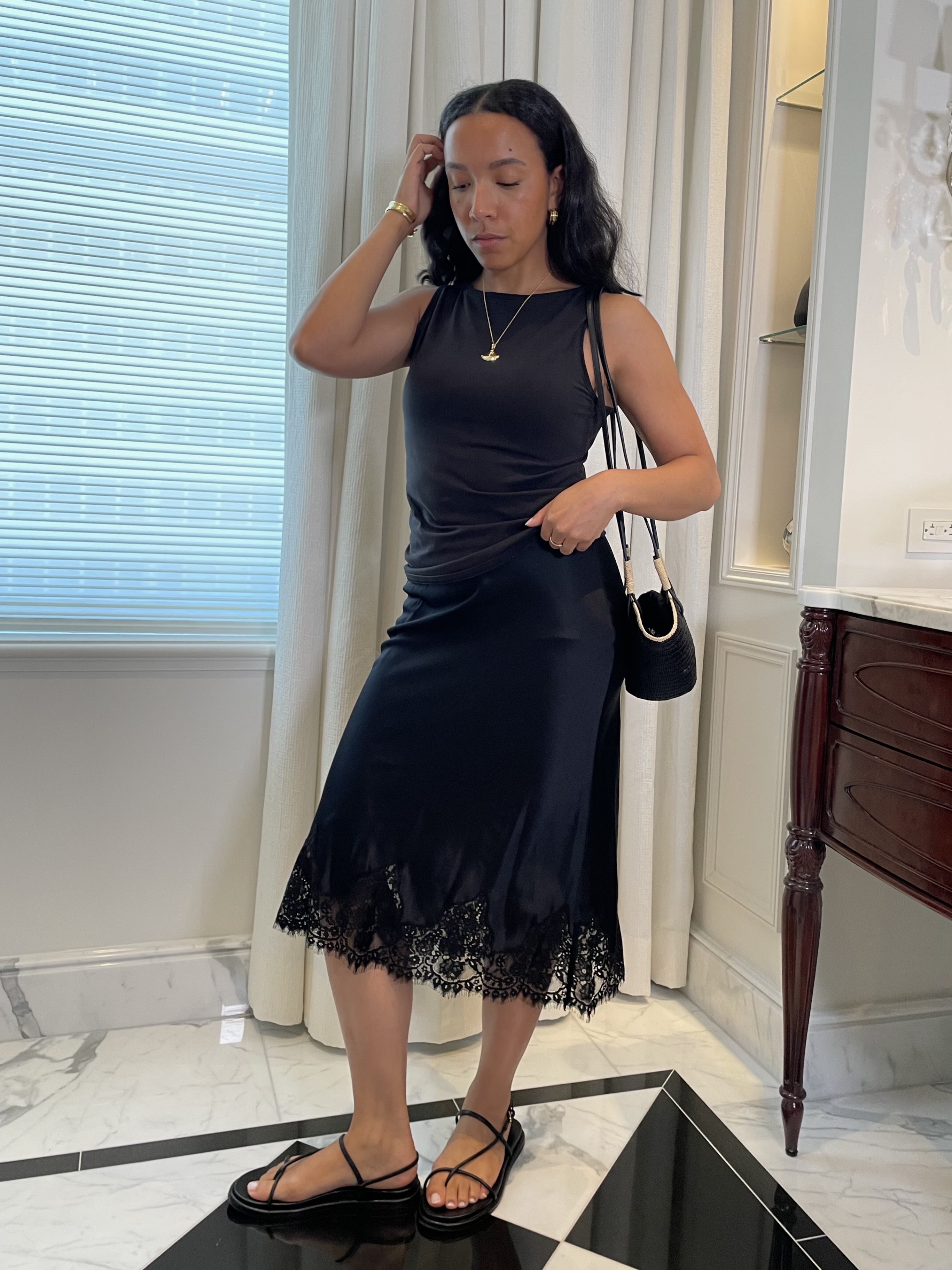 Lauren Tappan wearing a black top, a black lace skirt, and black sandals