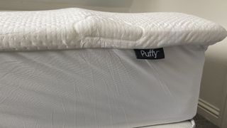 Puffy Deluxe Mattress Topper rolled on reviewer's bed