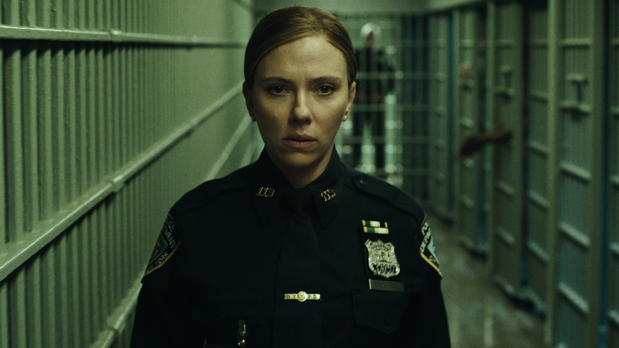 Julie Miller (Scarlett Johansson) looks uncomfortable as she makes her way down a corridor of cells in The Exorcist: The Martyrs.