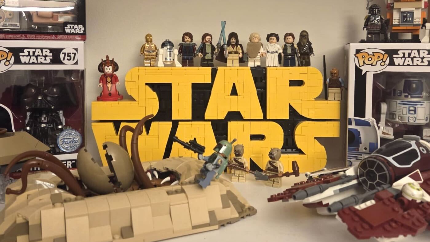 The final build of the Lego Star Wars Logo set surrounded by various Star Wars mini-figures and sets, showing the focal point of the Logo set