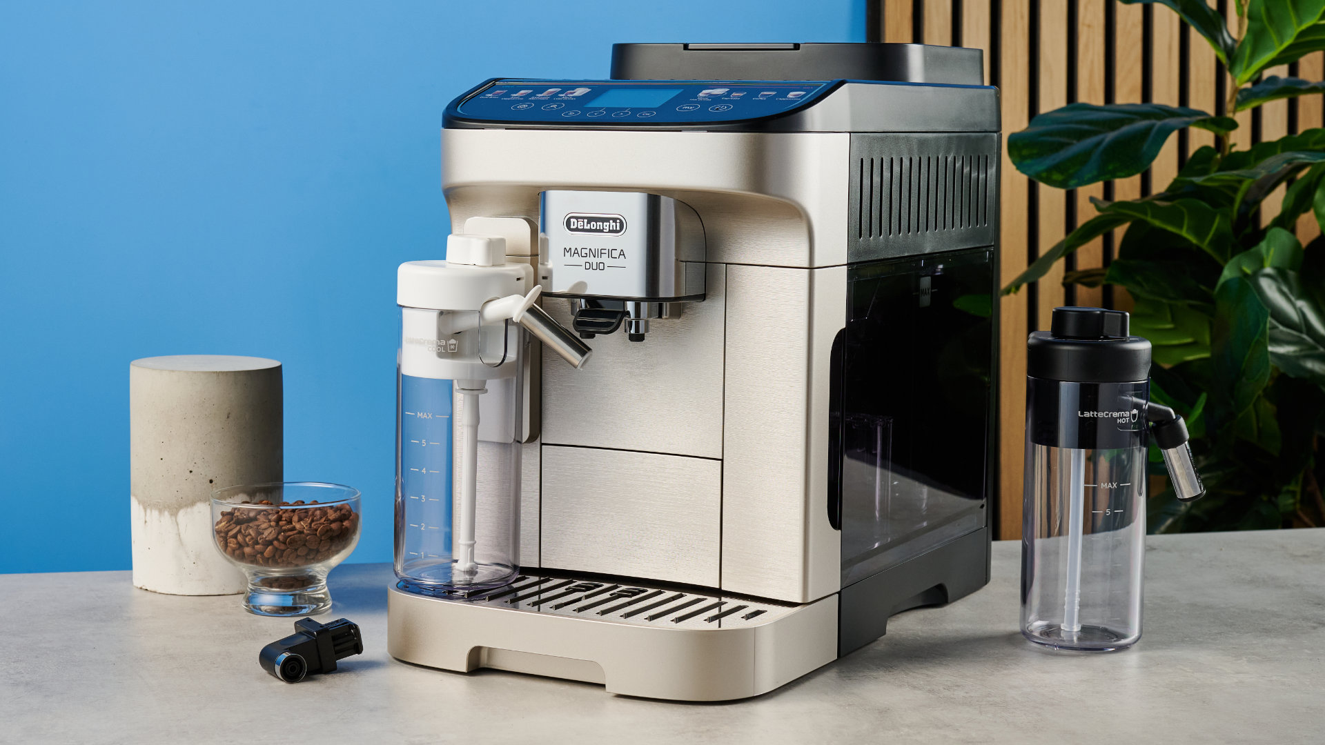 the de'longhi magnifica duo photographed with the blue tom's guide background showing the milk carafe and coffee machine screen