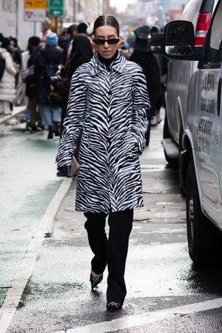 a woman wears a zebra-print coat