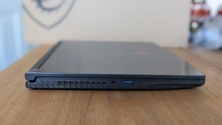 A black MSI GF63 Thin laptop on a wooden desk