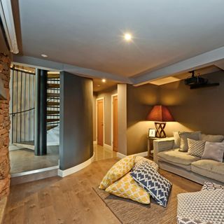 snug area with grey sofa and wooden flooring