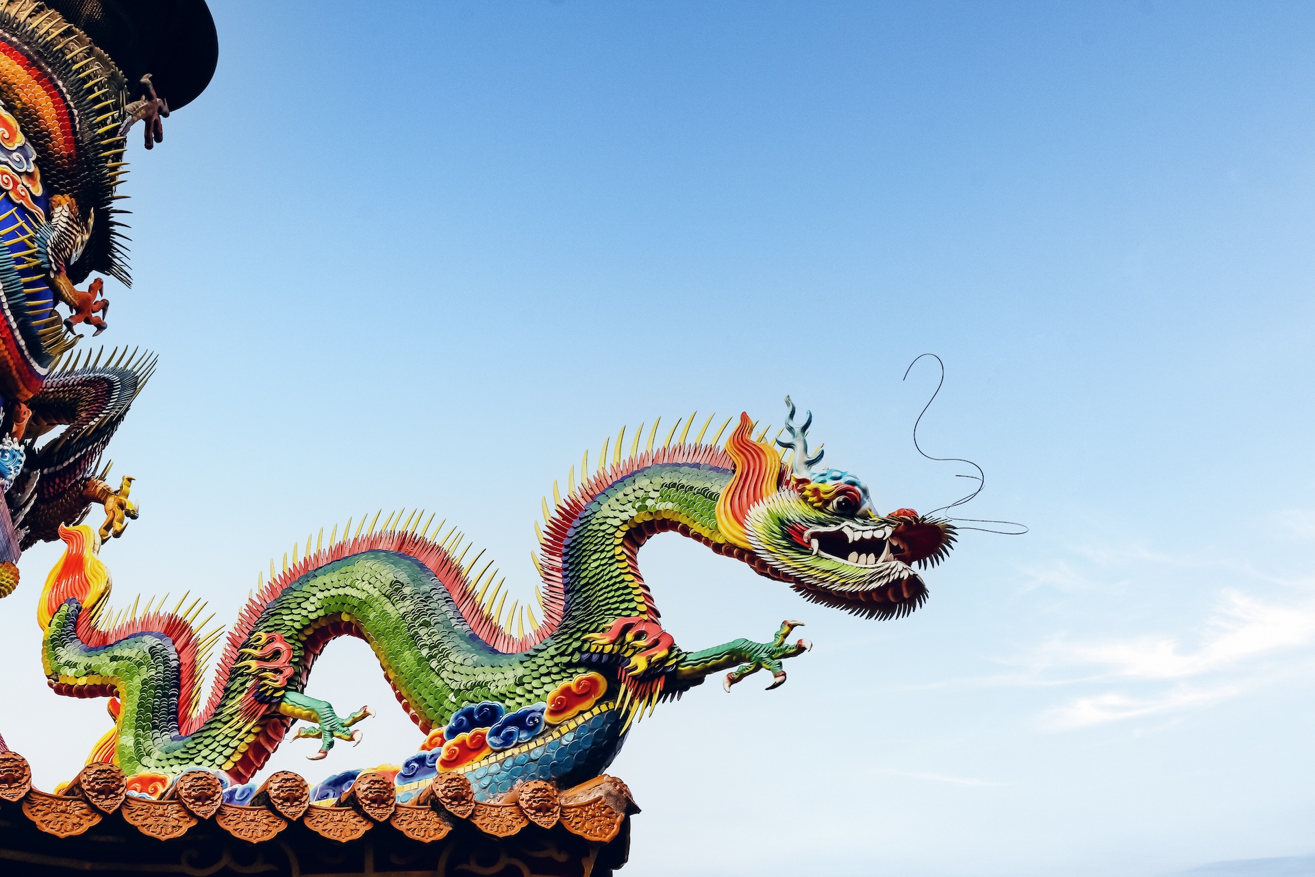 A colorful statue of a dragon on the side of a building