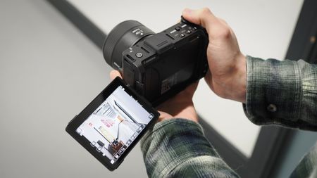 Mike Harris holding a Nikon ZR with 40mm lens in an office building