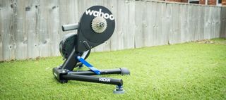 Wahoo Kickr smart trainer on some grass in front of a fence