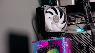 A Cooler Master Hyper 212 Pro air cooler with its packaging and installed on a gaming PC.