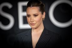 A headshot of Ashley Tisdale with her hair in a bun 