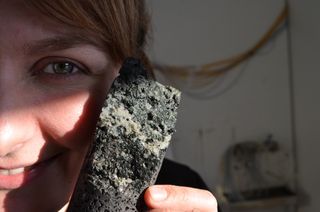 Study co-author Sandra Snaebjornsdottir holds a sample of volcanic rock that is loaded with solidified carbonate, formed when the researchers pumped carbon dioxide into the rock.