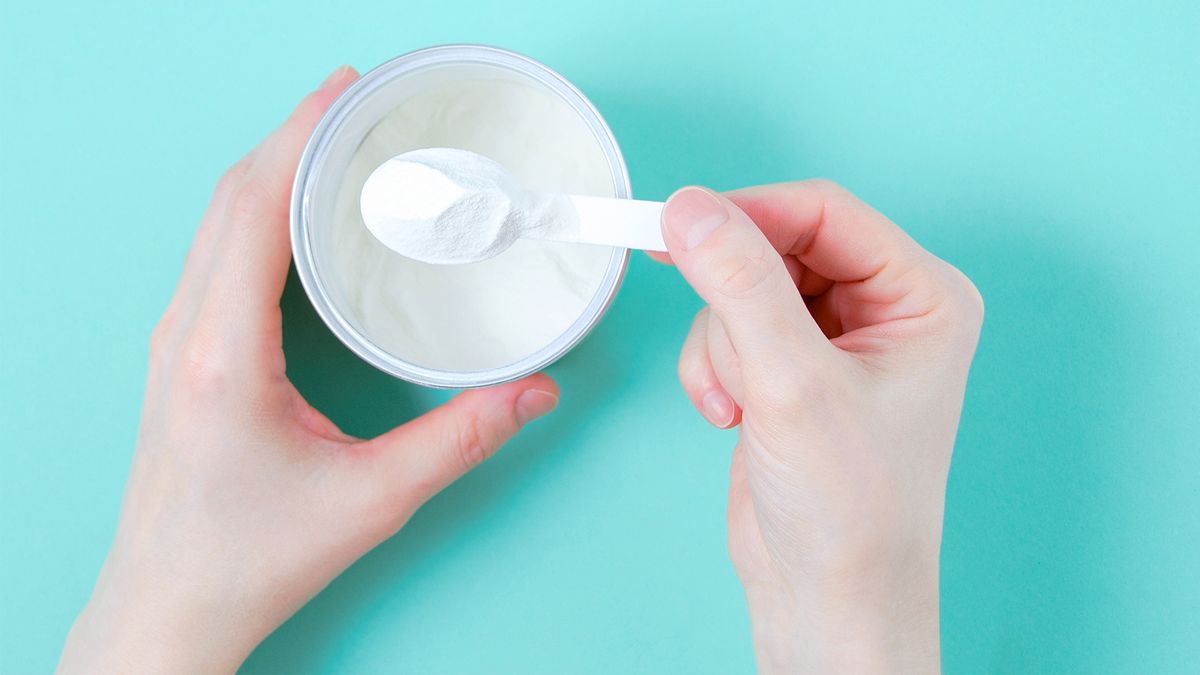 person scooping collagen powder