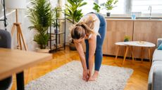 woman bends down to touch her toes