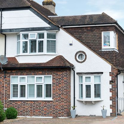 red brick and white wall house with roof and white window