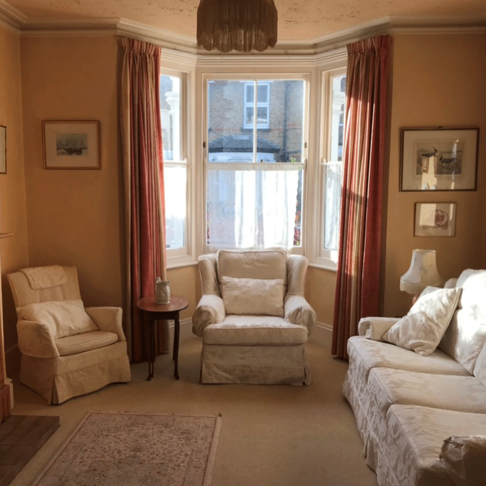 Living room with cream walls, cream furniture and bay window