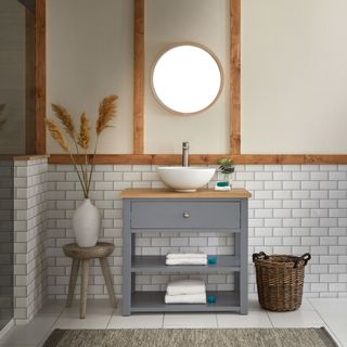 bathroom with white tiles on floor and half wall and basin
