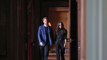 Prince Harry and Meghan Markle walking through a doorway