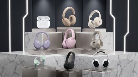 A collection of headphones in a futuristic shop window. The headphones are mostly pastel colors 