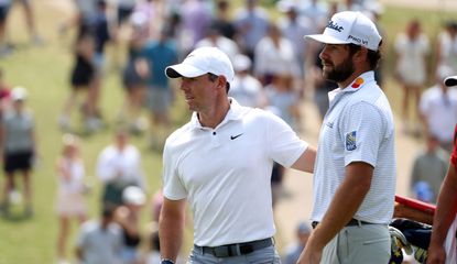 Rory McIlroy and Cameron Young walk off the green
