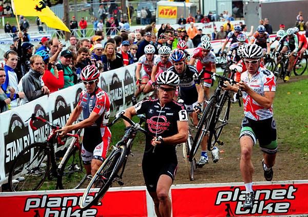 The men run the barriers at the start of the race.