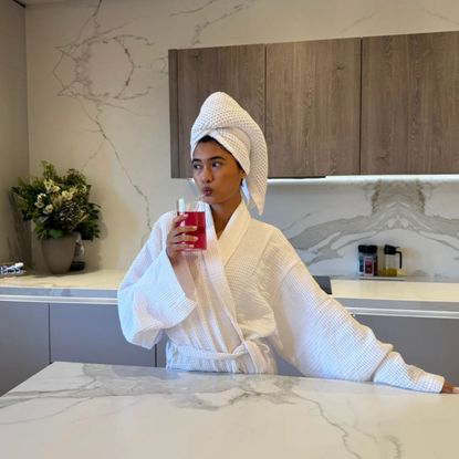 woman in dressing gown drinking Shreddy Superwoman supplement