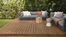 outdoor brown stained deck with two gray outdoor sofas and accent cushions