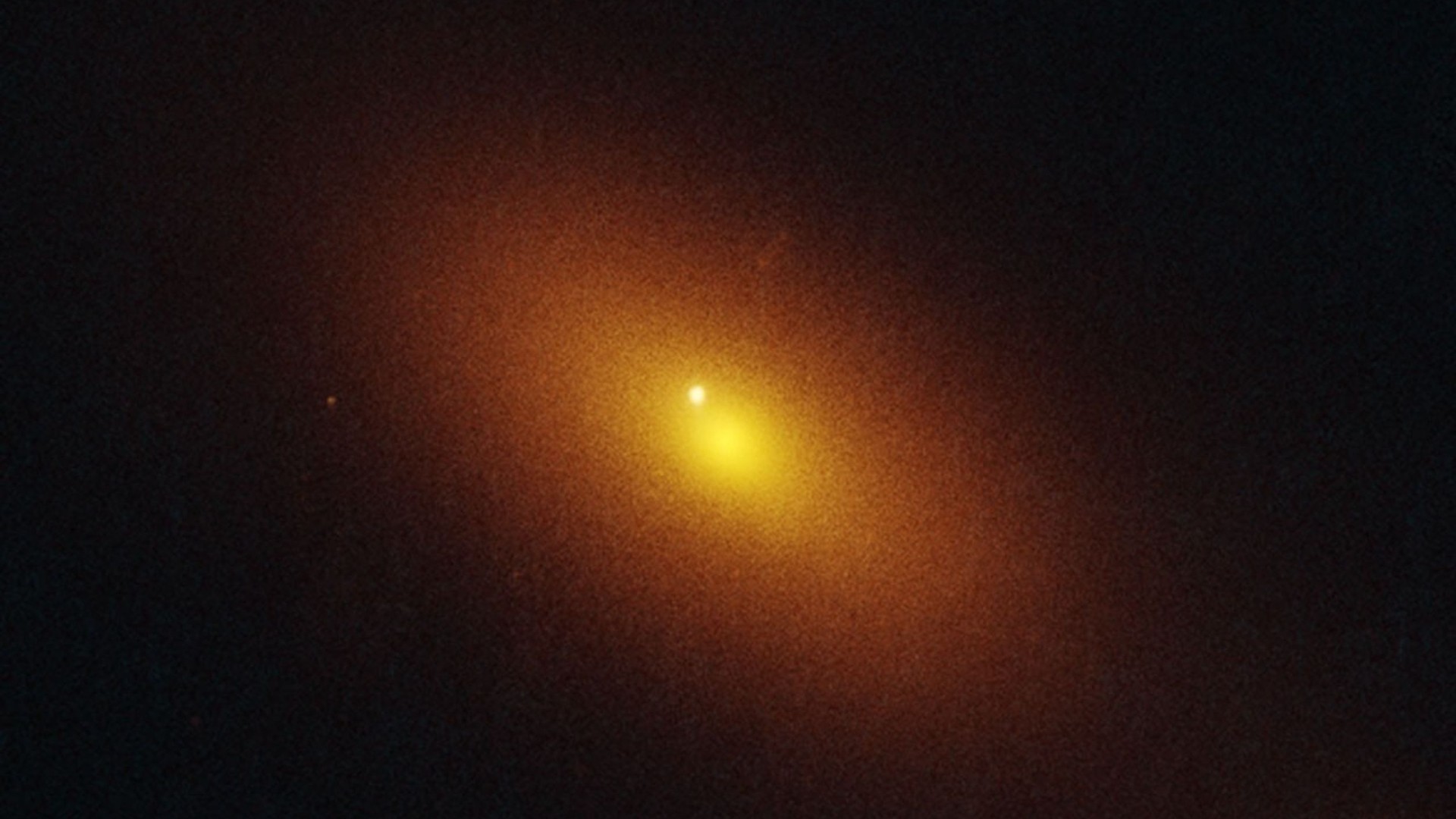 a bright white dot near the center of an orange cloud of light on a black background