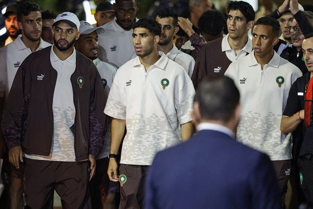 (LR) Os marroquinos Ismael Saibari, Achraf Hakimi e Soufiane Rahimi, juntamente com membros da seleção marroquina de futebol, são vistos à sua chegada a Rabat - Salé; Aeroporto de Salé; em 12 de julho de 2026, após retornar de Boston, nos Estados Unidos, após sua participação na Copa do Mundo de futebol de 2026. (Foto de Abdel Majid BZIOUAT/AFP)